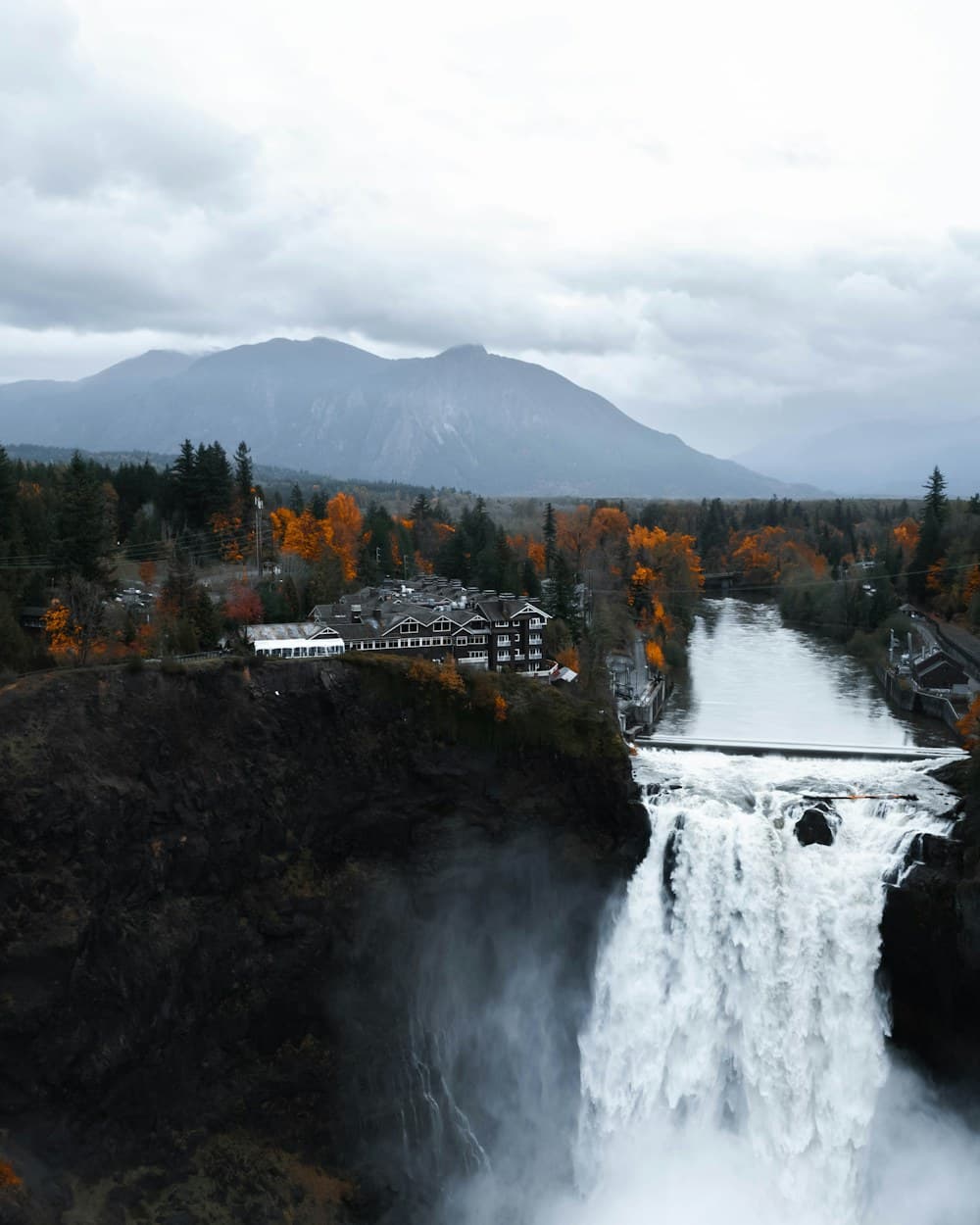 Snoqualmie Falls pouring into the gorge with the ridge line behind it