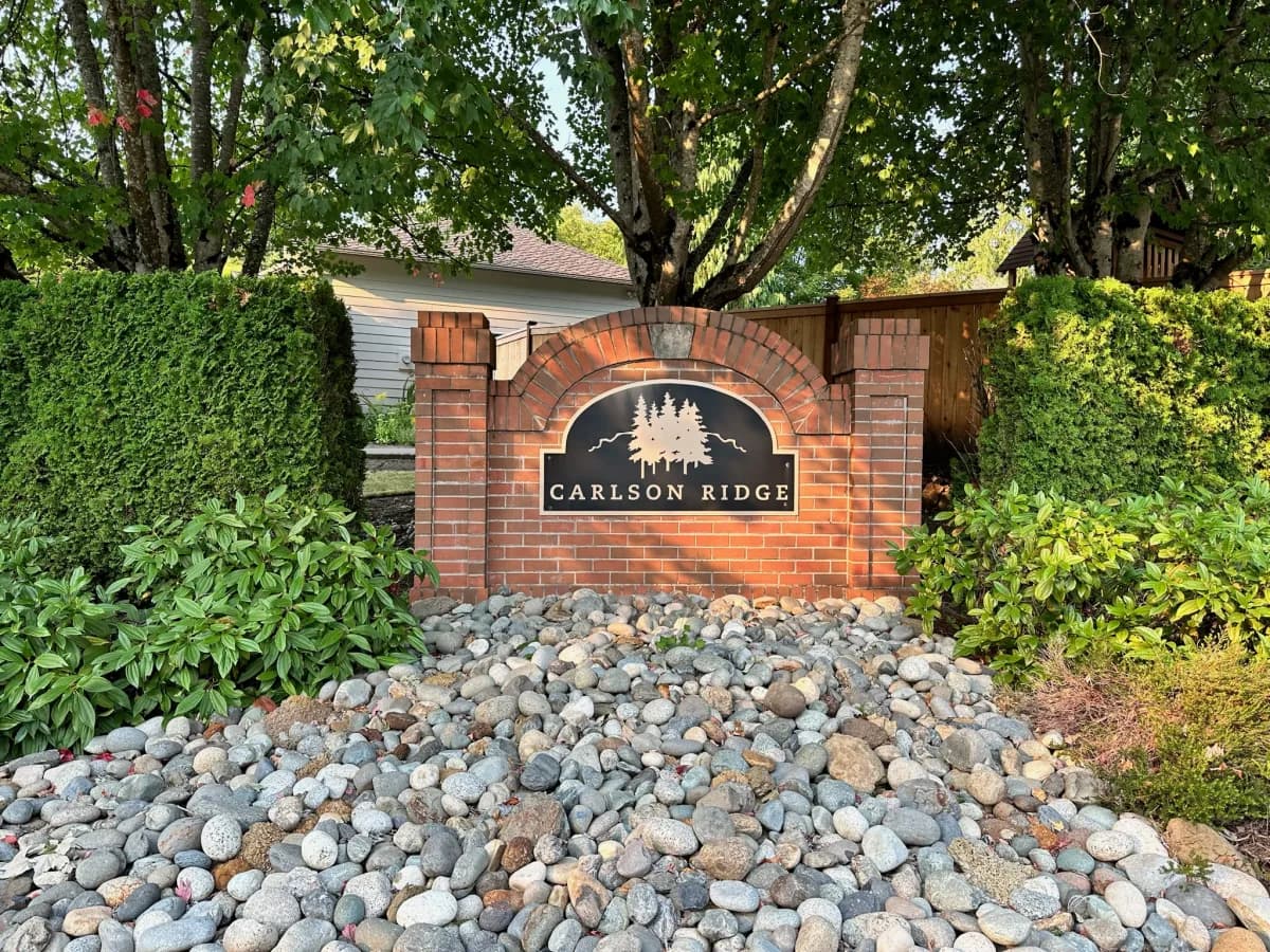 Carlson Ridge brick arch entry sign with forged evergreen tree design in Duvall WA