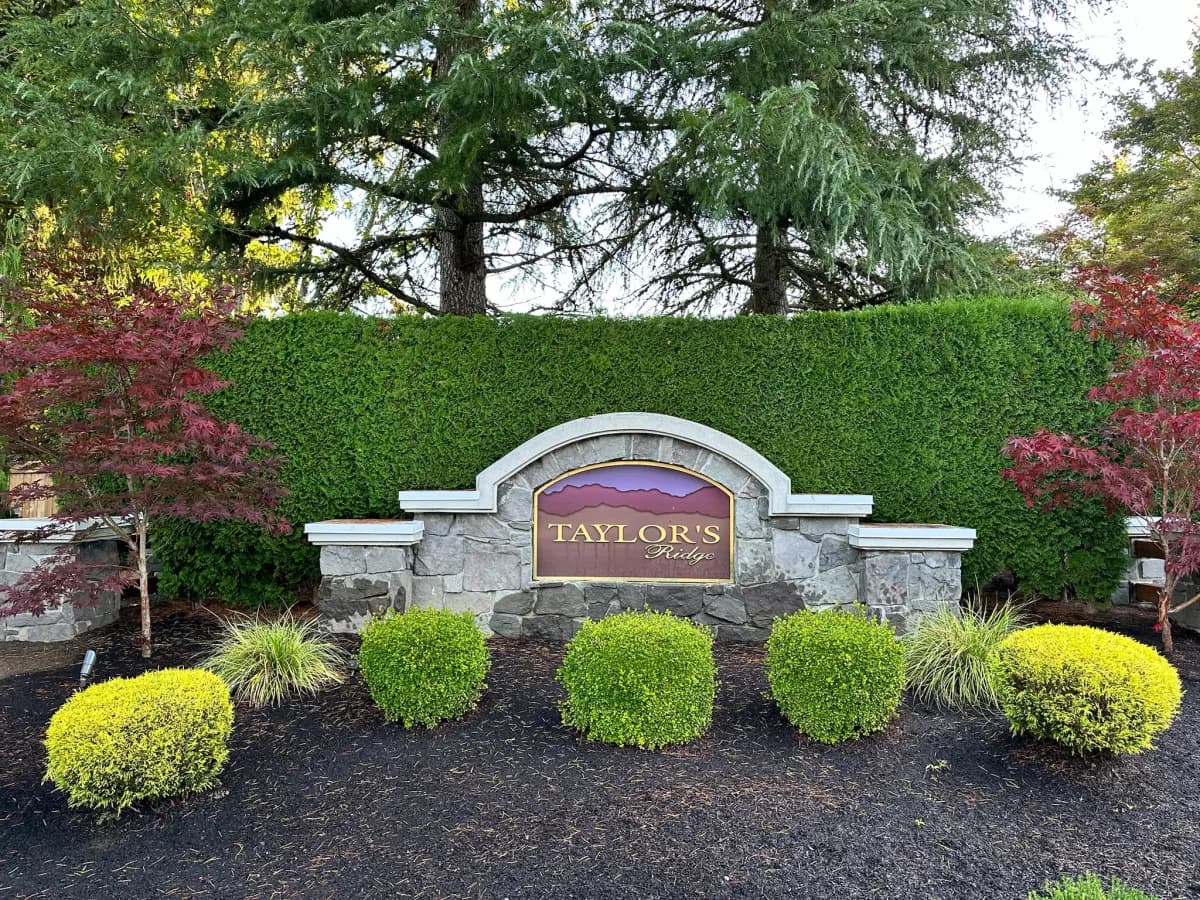 Taylor's Ridge arched stone monument entry sign with Cascade mountain mural in Duvall WA