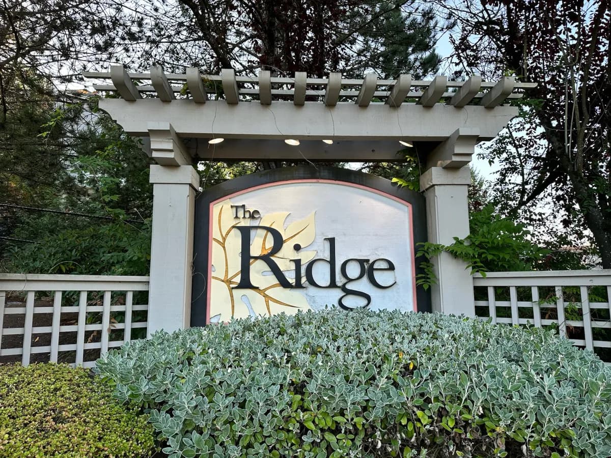 The Ridge pergola entry sign with gold leaf motif in Duvall WA
