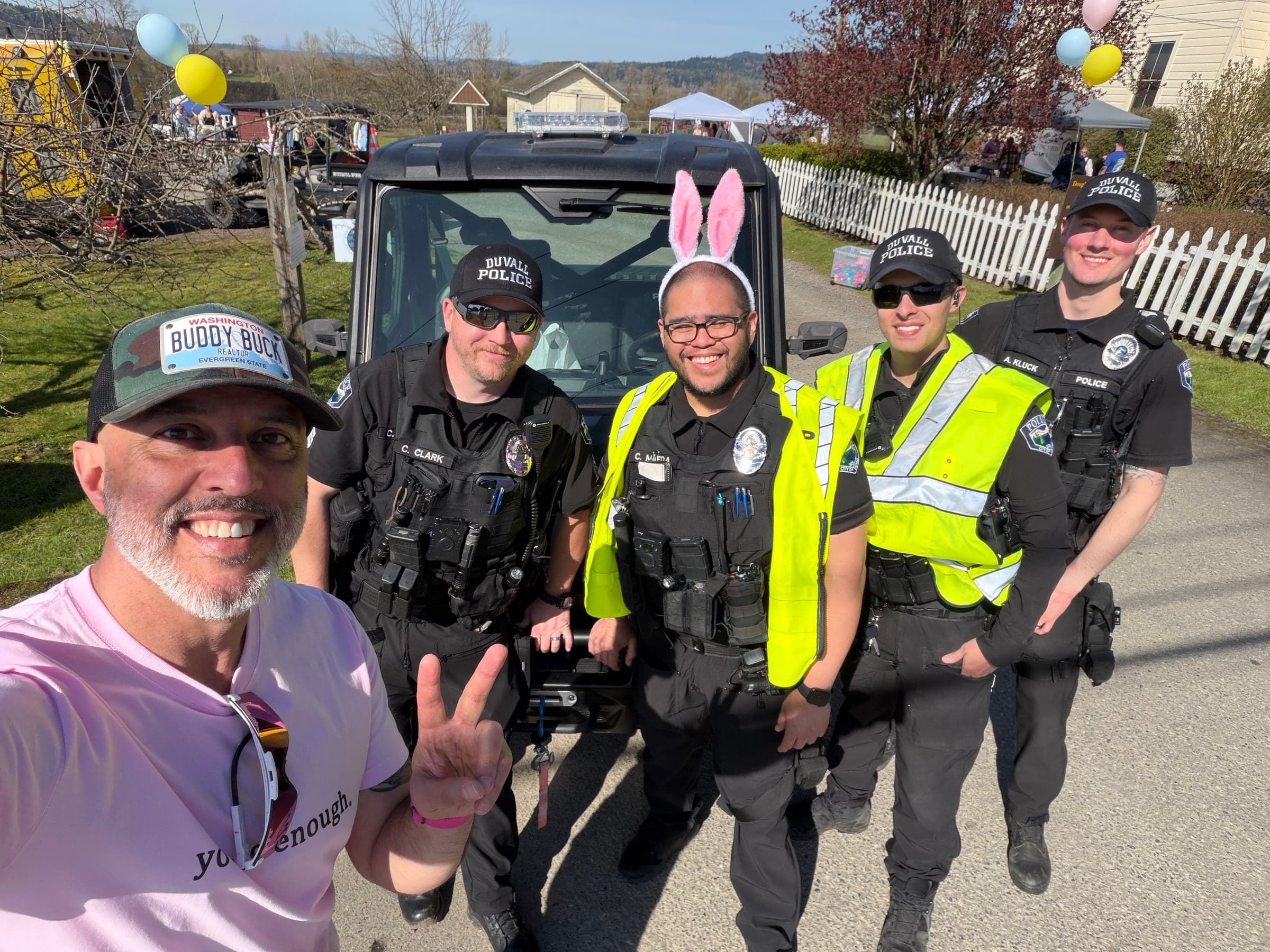 Buddy Buck and four Duvall police officers at the 2026 Easter egg hunt, one of them wearing bunny ears