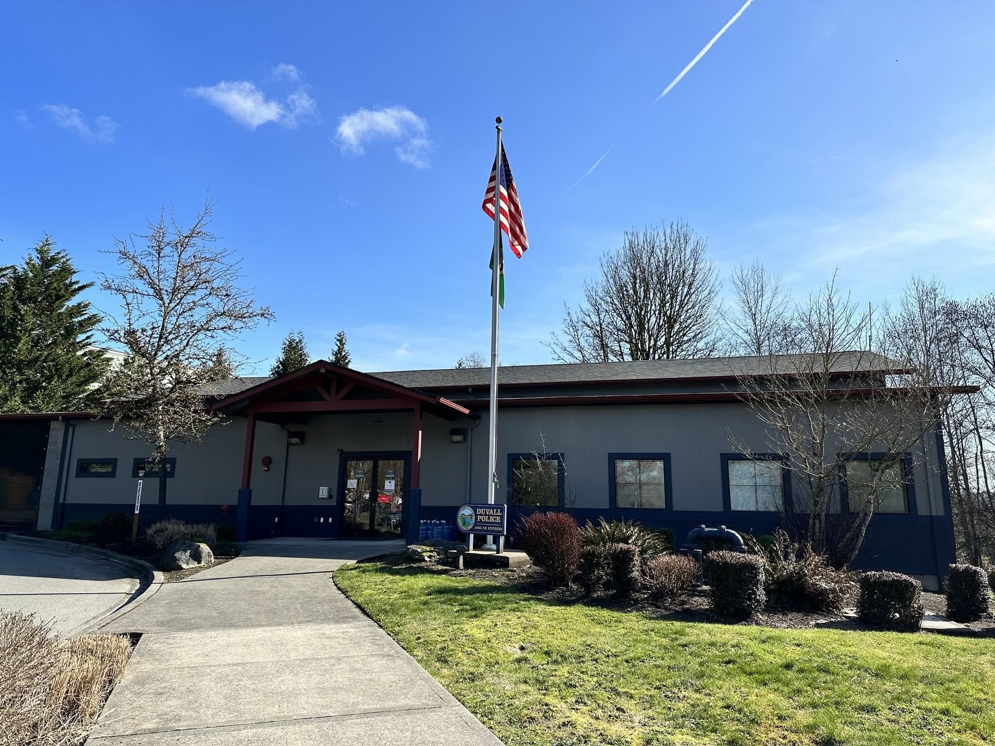 The Duvall Police station on a clear day, flag flying, with the department sign out front